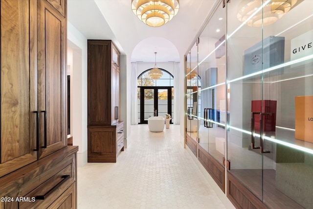 hall with light tile patterned floors, a high ceiling, and french doors