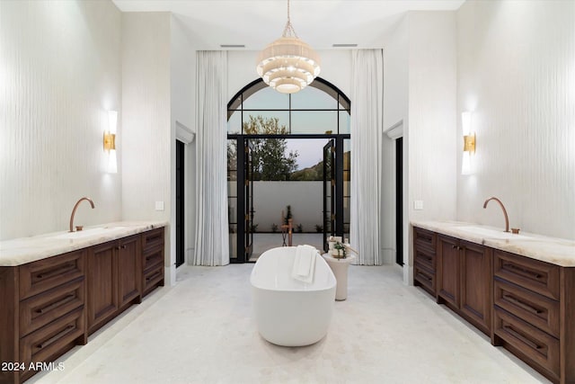 bathroom featuring a bathing tub, a towering ceiling, vanity, and a chandelier