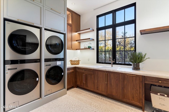 laundry area featuring a sink, cabinet space, and stacked washer / drying machine