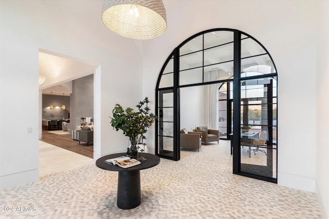 carpeted foyer entrance with a towering ceiling