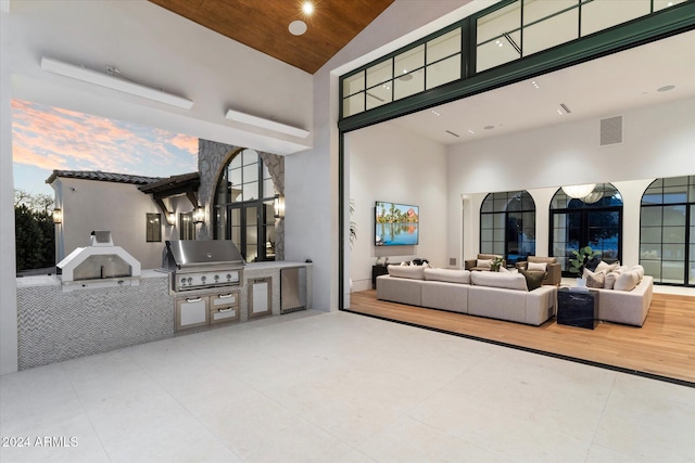 tiled living room featuring wood ceiling, high vaulted ceiling, and visible vents