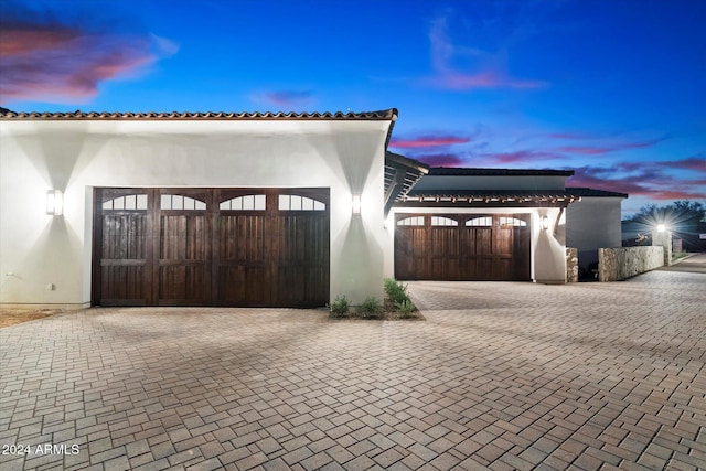 view of front of home featuring a garage, a gate, decorative driveway, and stucco siding