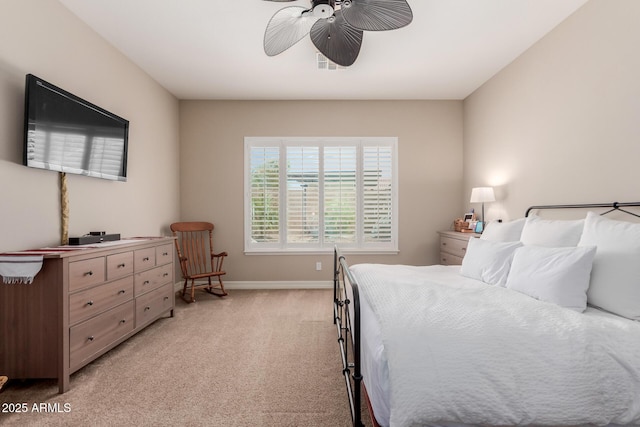 bedroom with visible vents, light colored carpet, baseboards, and ceiling fan