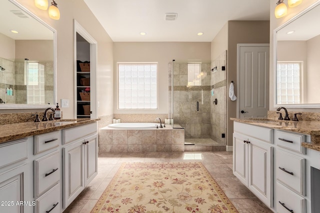 full bathroom featuring a healthy amount of sunlight, a stall shower, and a sink