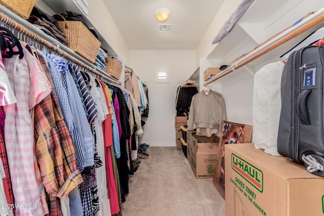 walk in closet featuring visible vents and light colored carpet