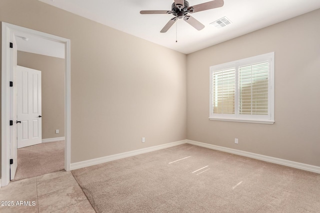 empty room with baseboards, a ceiling fan, visible vents, and light carpet