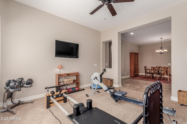 exercise area with ceiling fan with notable chandelier, baseboards, and carpet floors