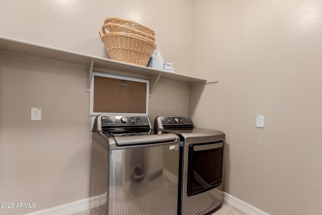 laundry area with laundry area, baseboards, and washing machine and clothes dryer