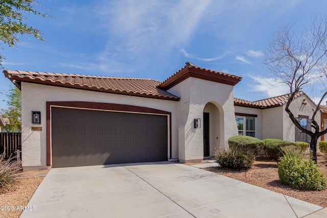 mediterranean / spanish-style house with a garage, driveway, and stucco siding