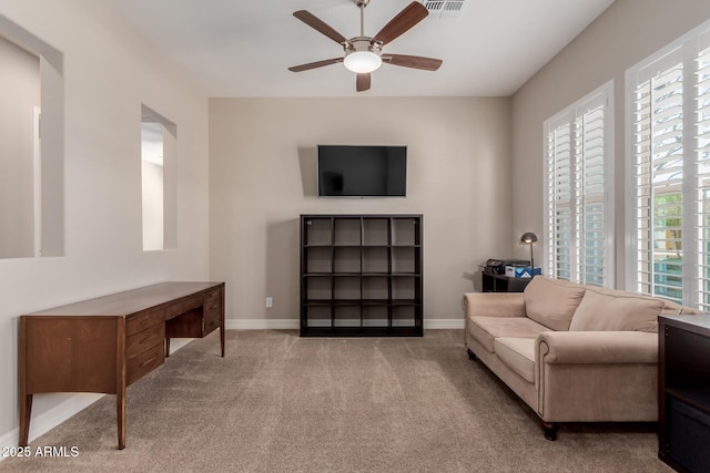 living area with visible vents, baseboards, carpet, and a ceiling fan