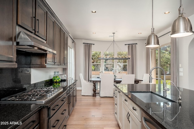 11070 E Bent Tree Dr, Scottsdale, AZ 85262 - kitchen with stainless steel appliances, under cabinet range hood, dark brown cabinets, recessed lighting, and dark stone countertops