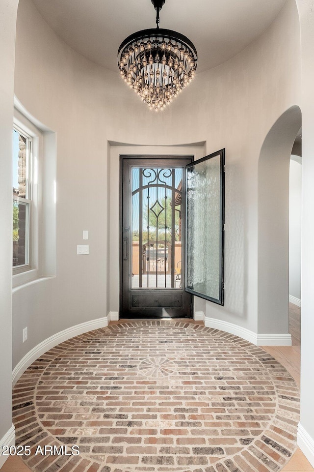 11070 E Bent Tree Dr, Scottsdale, AZ 85262 - entrance foyer featuring brick flooring, arched walkways, and a chandelier