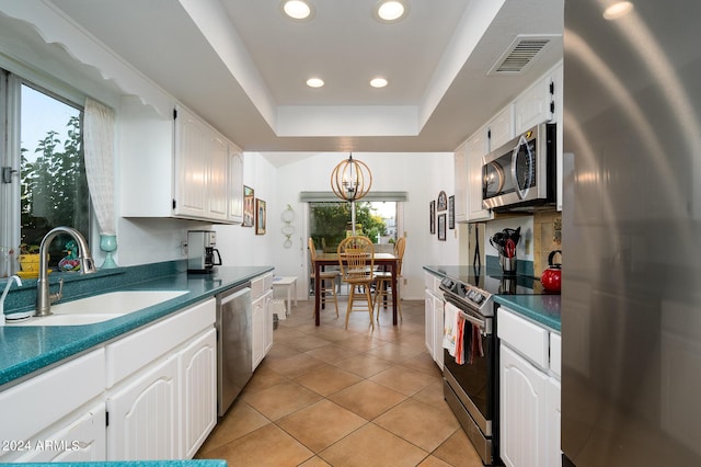 kitchen with a sink, visible vents, white cabinets, appliances with stainless steel finishes, and dark countertops