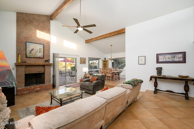 living area with beam ceiling, light tile patterned floors, a brick fireplace, high vaulted ceiling, and ceiling fan with notable chandelier