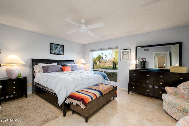 bedroom with light tile patterned floors, visible vents, a ceiling fan, and a textured ceiling