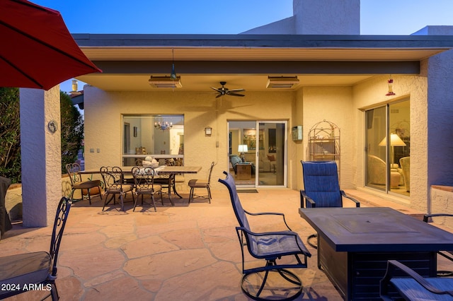 view of patio featuring ceiling fan, a fire pit, and outdoor dining area