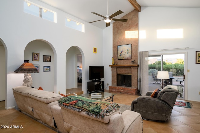 living room with arched walkways, high vaulted ceiling, light tile patterned floors, a fireplace, and beam ceiling