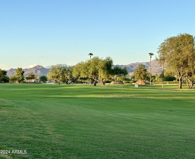 surrounding community with a mountain view, golf course view, and a yard