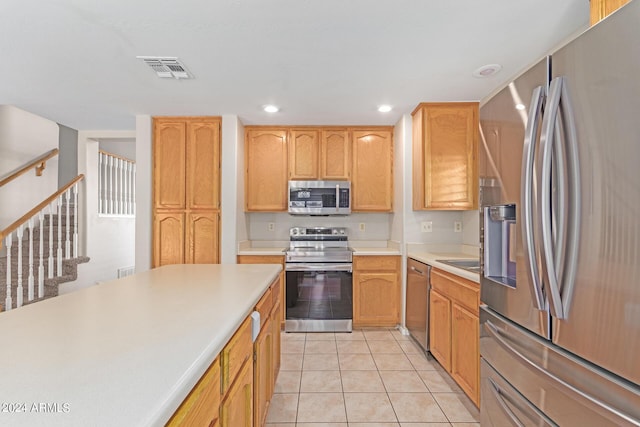 kitchen with light tile patterned floors, stainless steel appliances, recessed lighting, light countertops, and visible vents