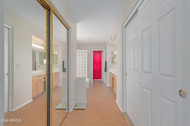 hall featuring light tile patterned floors and baseboards