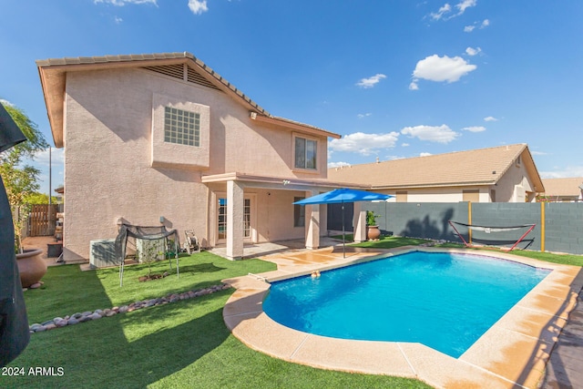 view of swimming pool featuring a fenced in pool, a patio area, a fenced backyard, and a yard