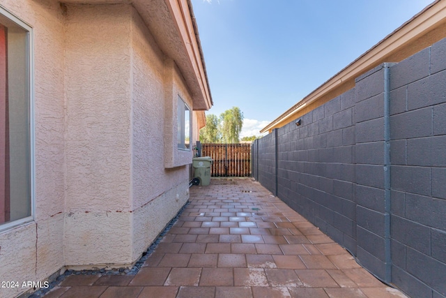 view of side of property featuring a patio area, fence, and stucco siding