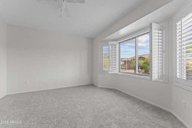 carpeted empty room with baseboards, plenty of natural light, lofted ceiling, and a ceiling fan