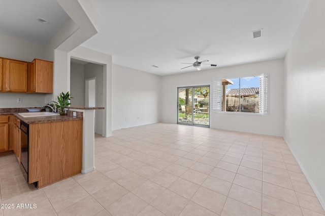 kitchen with dark countertops, ceiling fan, open floor plan, dishwasher, and a sink