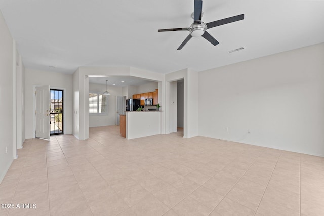 unfurnished living room featuring light tile patterned floors, visible vents, and ceiling fan