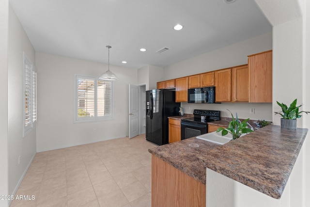 kitchen featuring dark countertops, recessed lighting, black appliances, and a sink