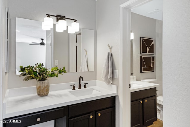 full bath featuring vanity, toilet, and a ceiling fan