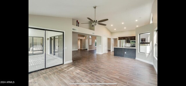 unfurnished living room featuring ceiling fan, light hardwood / wood-style flooring, and high vaulted ceiling