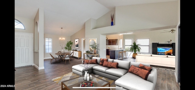 living room featuring ceiling fan with notable chandelier, high vaulted ceiling, dark hardwood / wood-style flooring, and a healthy amount of sunlight