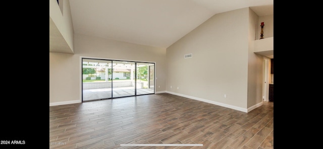 empty room with high vaulted ceiling and wood-type flooring