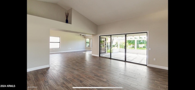 spare room featuring ceiling fan, dark hardwood / wood-style floors, high vaulted ceiling, and a wealth of natural light