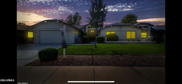 view of front of home with a garage and a lawn