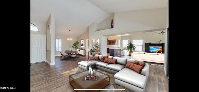 living room featuring wood-type flooring, ceiling fan with notable chandelier, and high vaulted ceiling