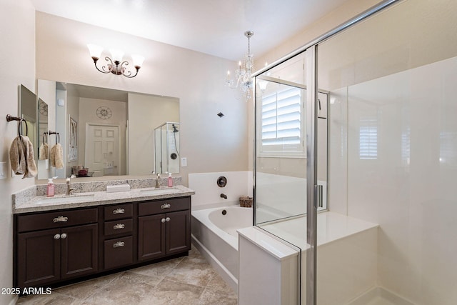 bathroom featuring vanity, independent shower and bath, and an inviting chandelier