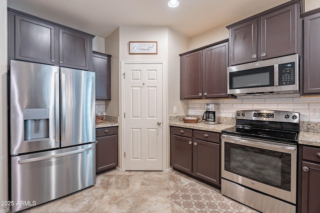 kitchen featuring stainless steel appliances, dark brown cabinets, light stone counters, and decorative backsplash