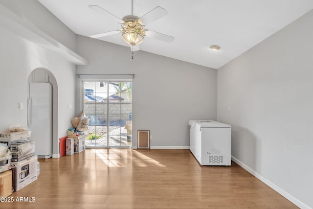 interior space with ceiling fan, lofted ceiling, and light wood-type flooring