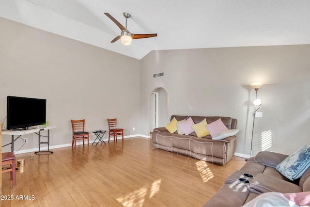 living room with ceiling fan, vaulted ceiling, and light wood-type flooring