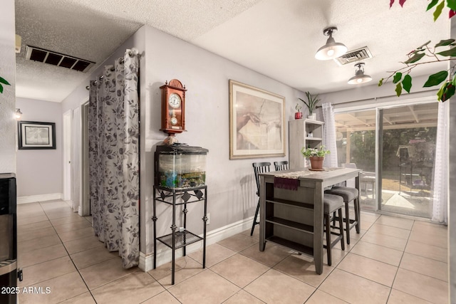 dining space with light tile patterned floors and a textured ceiling