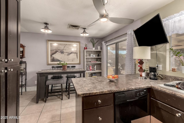 kitchen featuring ceiling fan, light tile patterned flooring, black dishwasher, dark brown cabinetry, and a textured ceiling