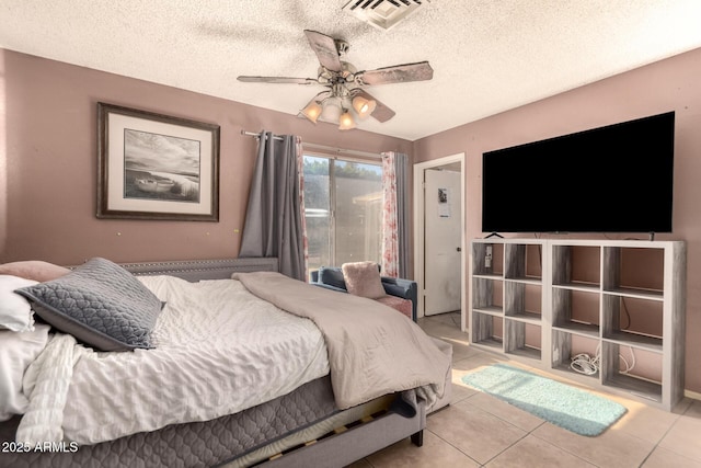 bedroom with ceiling fan, a textured ceiling, and light tile patterned floors