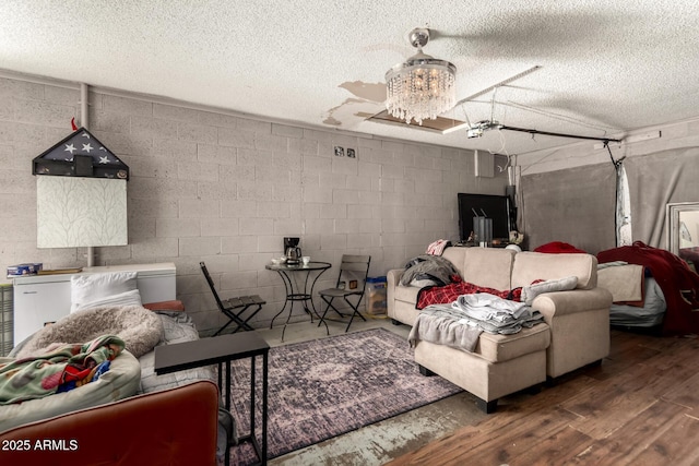 living room with wood-type flooring, an inviting chandelier, and a textured ceiling