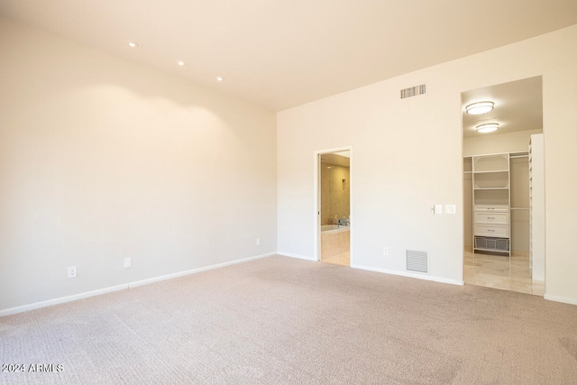 unfurnished room featuring light carpet