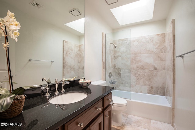 full bathroom featuring vanity, tile patterned floors, tiled shower / bath, a skylight, and toilet