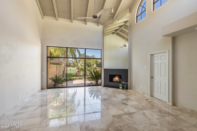 unfurnished living room with plenty of natural light, wooden ceiling, and high vaulted ceiling