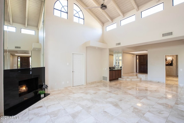 living room featuring beamed ceiling, ceiling fan, wood ceiling, and high vaulted ceiling