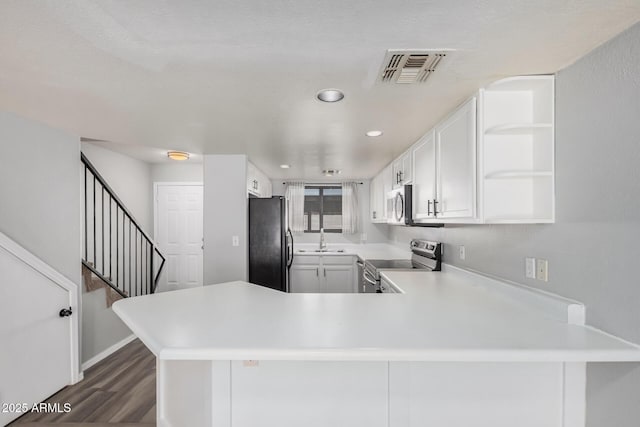 kitchen featuring kitchen peninsula, appliances with stainless steel finishes, and white cabinetry